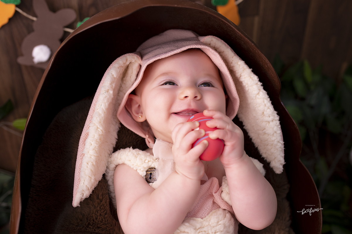 a menina esta vestida de coelhinha no ensaio infantil