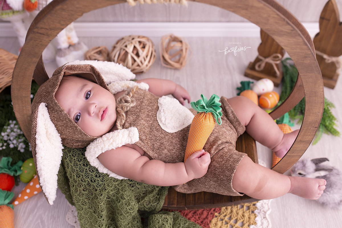 o bebe esta vestido de coelho para as fotos mensais
