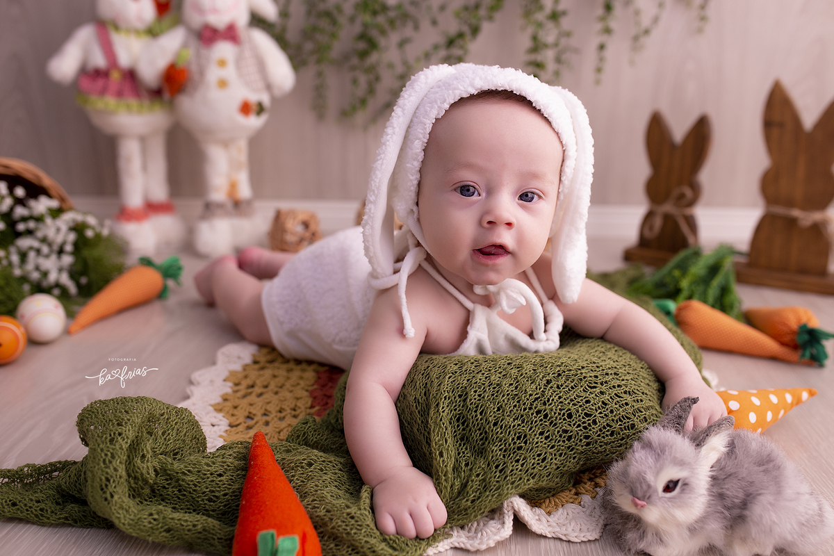 o bebe esta de bruços para as fotos de pascoa
