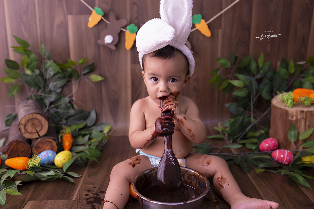 o menino se lambuza com chocolate no ensaio infantil