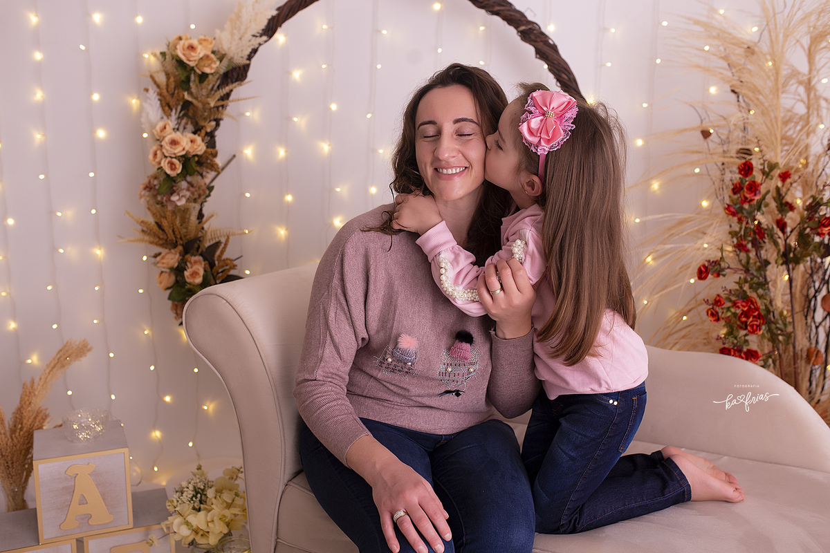 no ensaio de dia dAS MAES, a filha beija a mae
