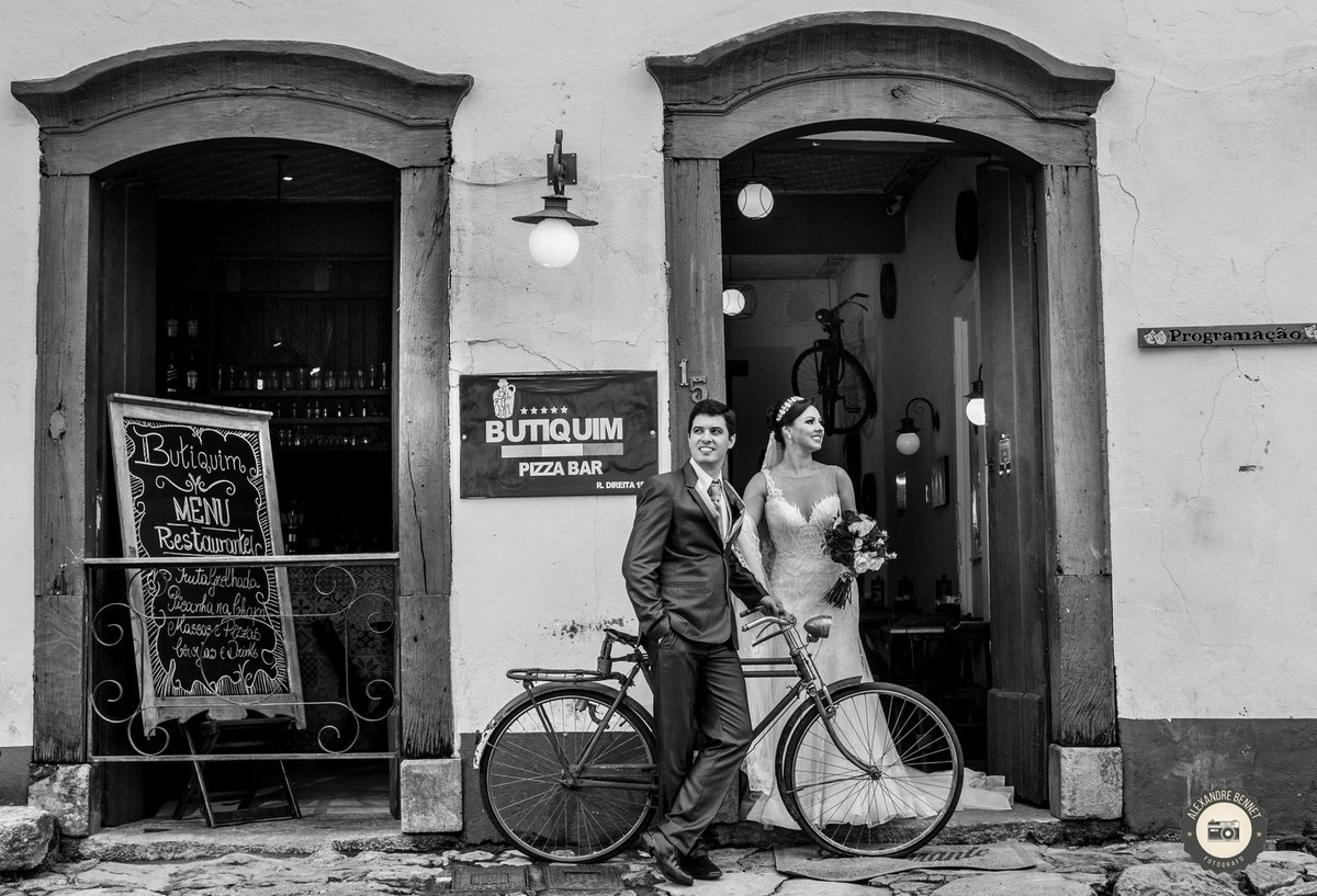 Casal posa para foto ao lado de uma bicicleta antiga uma bela foto de um ensaio pós casamento 