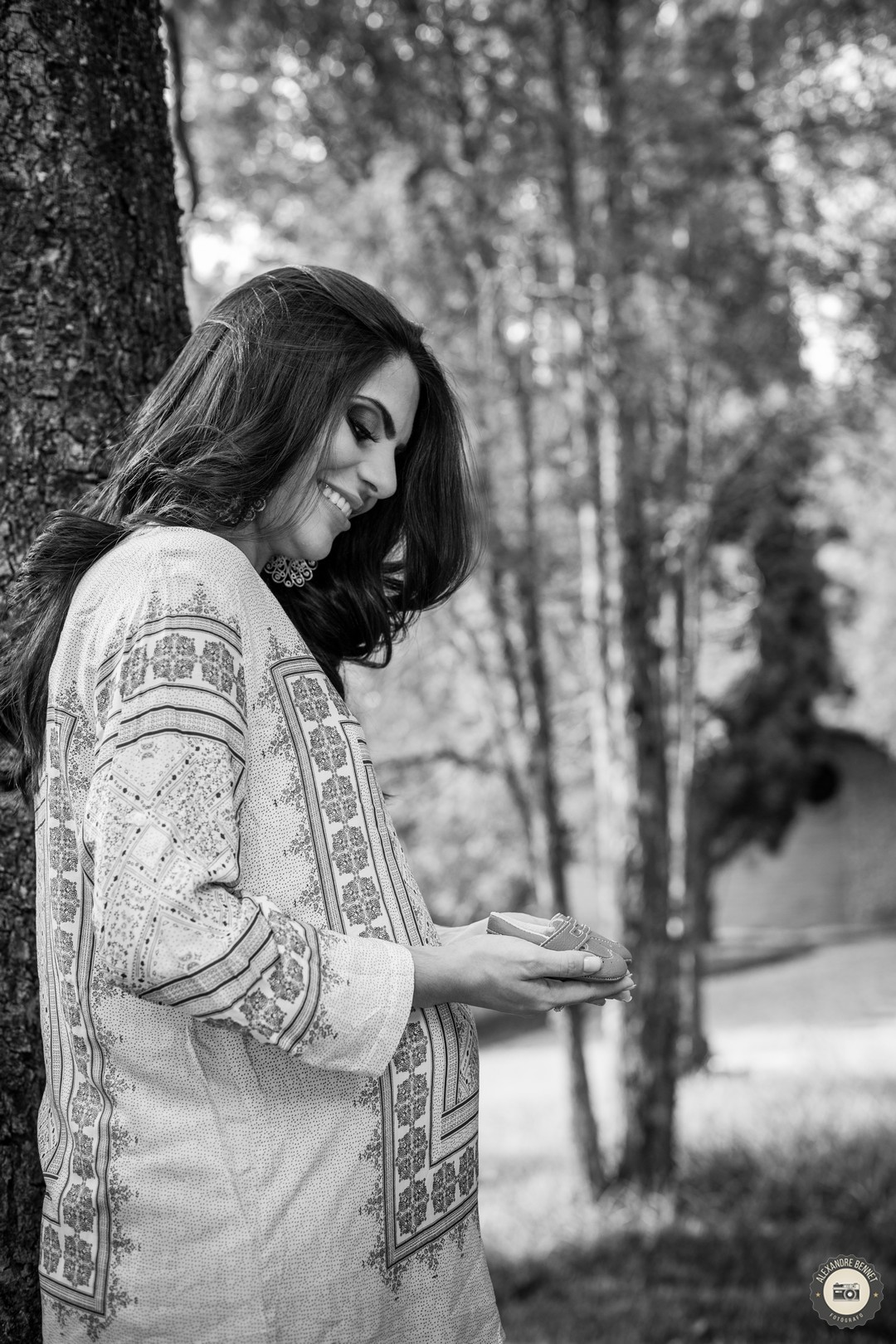 Com um belo sorriso no rosto ela observa os sapatinhos de bebê 