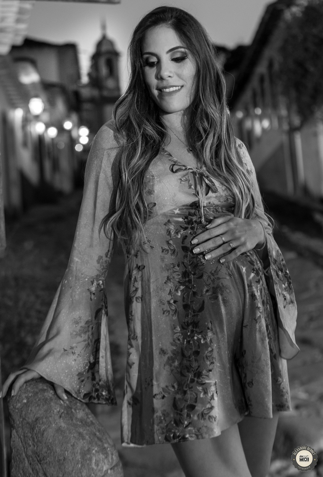 Gestante com a mão sobre sua barriga na rua de uma das cidades históricas mais importantes da história Tiradentes-MG 