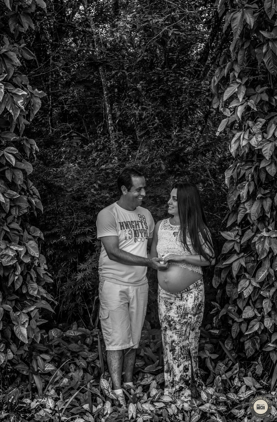 Pai e gestante se olham e sorriem mostrando a felicidade dos dois