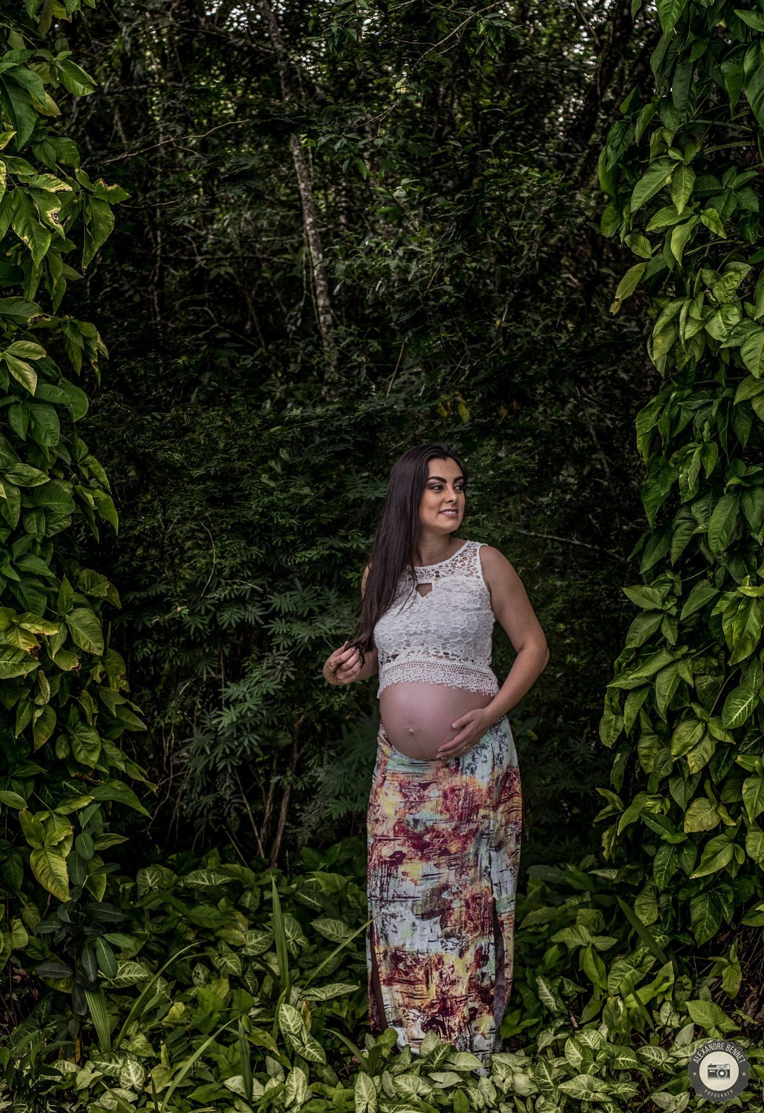 Gestante com uma bela paisagem natural de fundo da um belo sorriso