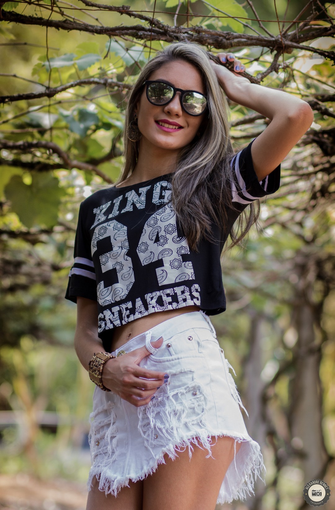 Com uma bela paisagem natural de fundo a jovem sorri pra foto