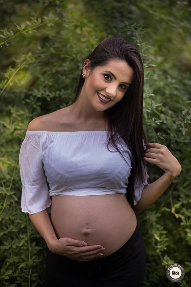 Olhando para o fotógrafo a gestante  capricha na pose 