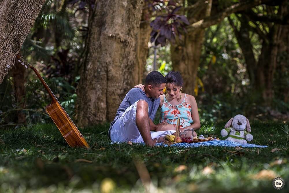 Casal se abraça e fixa o olhar sobre a barriga da grávida 