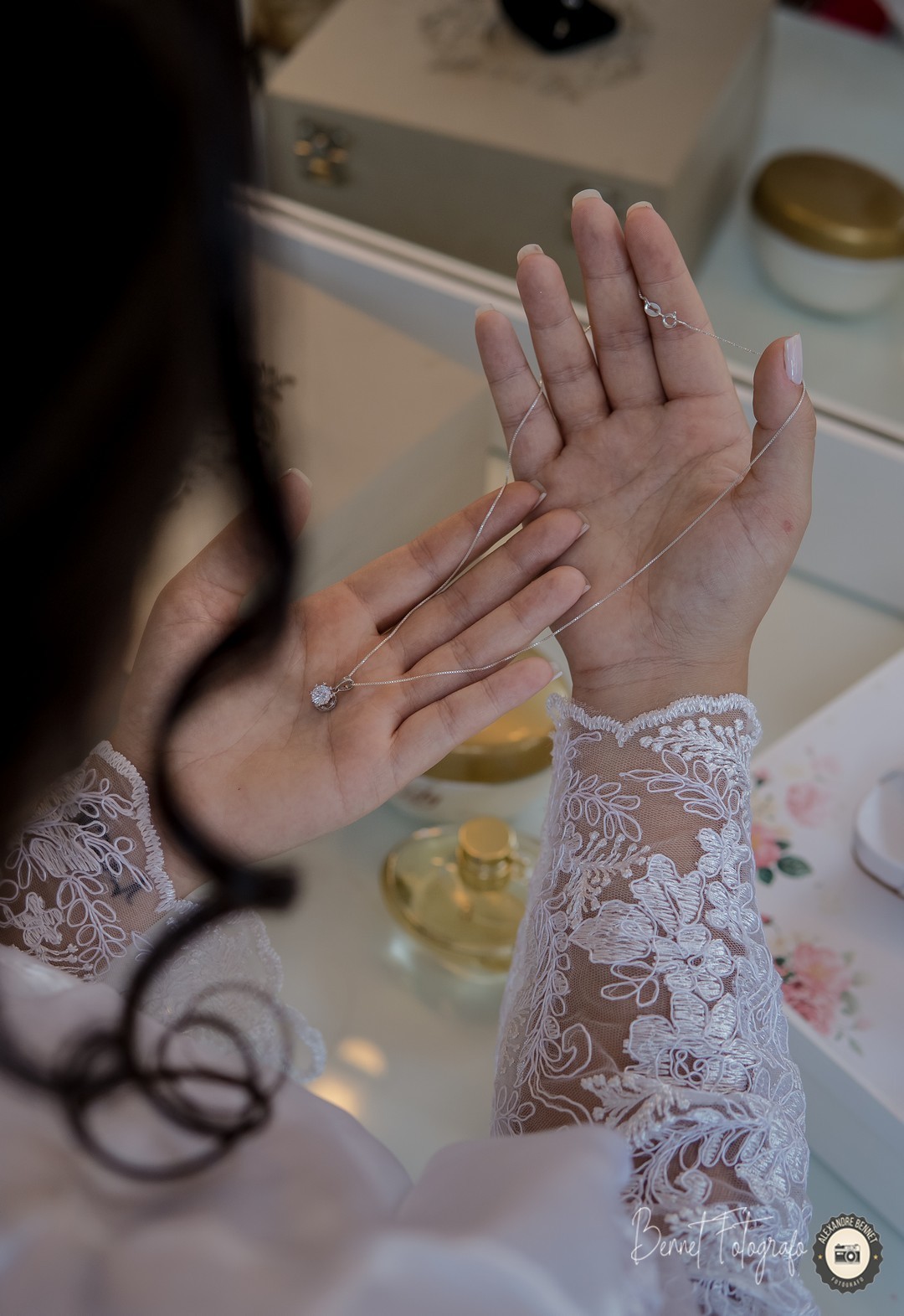 Noiva observa seu colar de pingente branco para combinar com o vestido