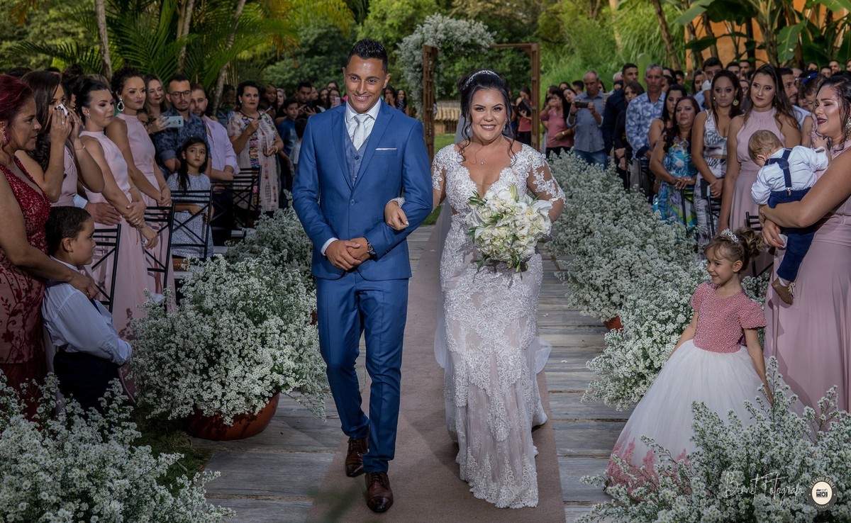 Noivo e noiva caminham de braços dados até ao altar onde dirão o tão esperado sim