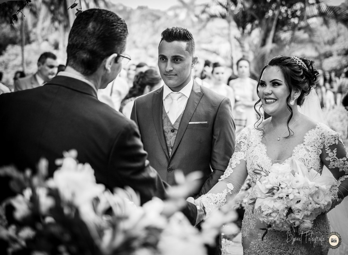 Pastor cumprimenta o casal no início da celebração do casamento 