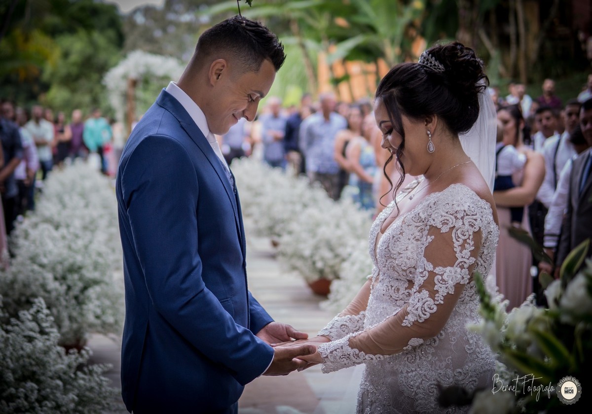 Noivos ficam de frente um pro outro de mãos dadas e com um belo sorriso no rosto 