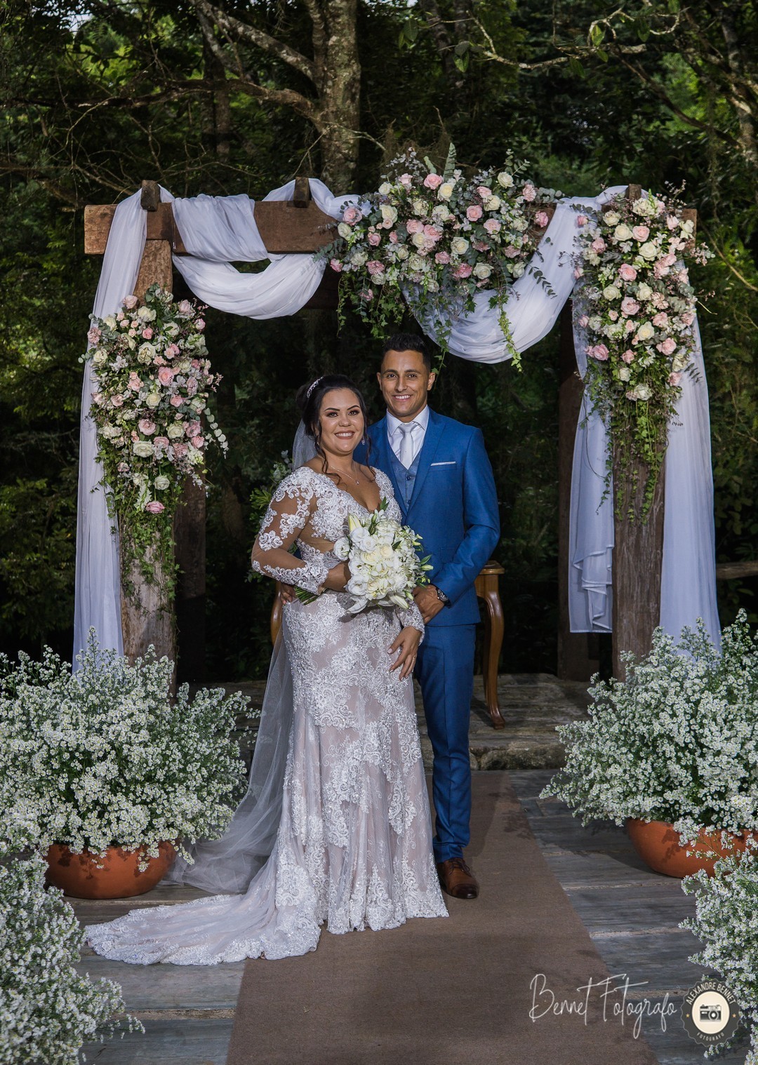 Noiva e noivo após a celebração posam para foto com um belo sorriso demonstrando a felicidade de ambos 