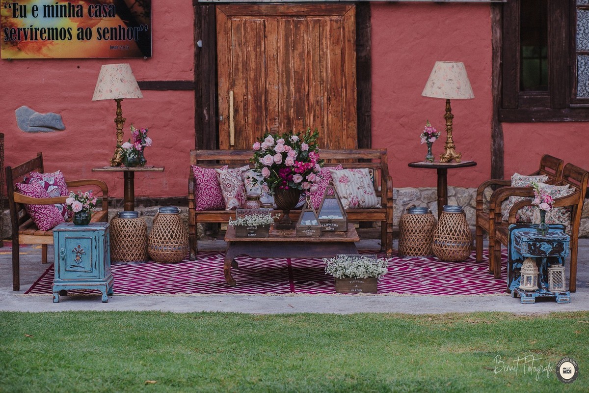 Bancos decorados com almofadas e flores paras os convidados descansarem durante a festa do casamento 