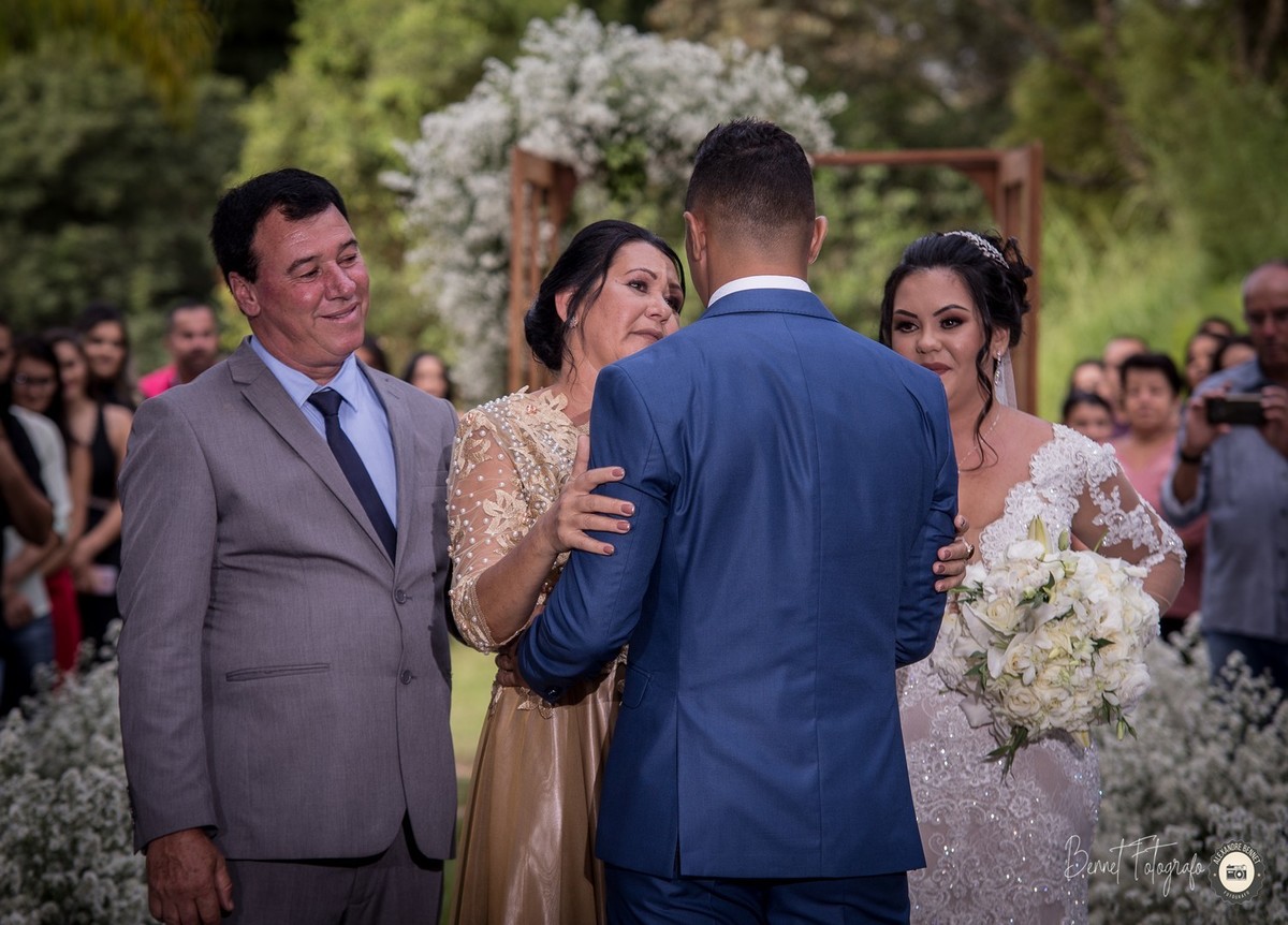 Mãe da noiva olhando e cumprimentando o noivo antes do casal seguir para o altar 