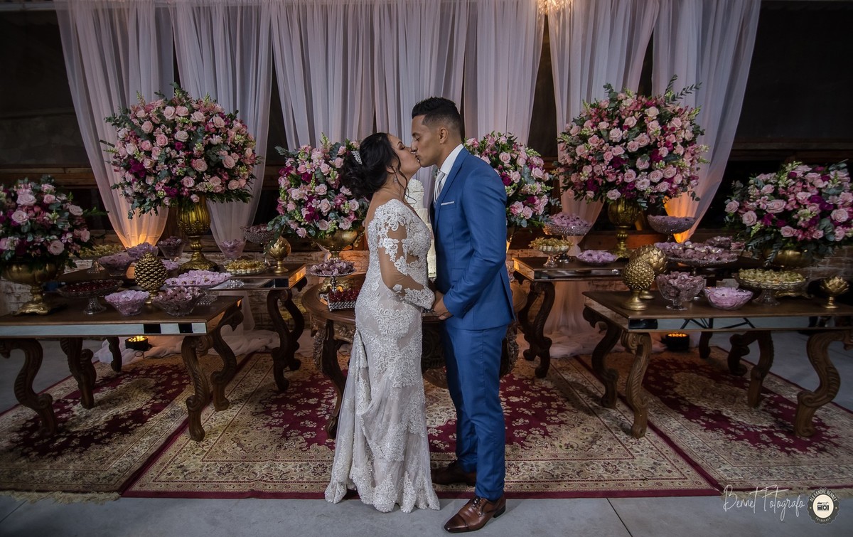 O grande beijo em frente a mesa do bolo durante a animada festa