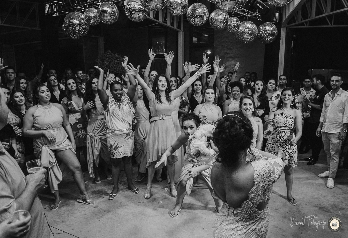 Noiva jogando o buquê e madrinhas animadas ao fundo apreensivas para pegá-lo 