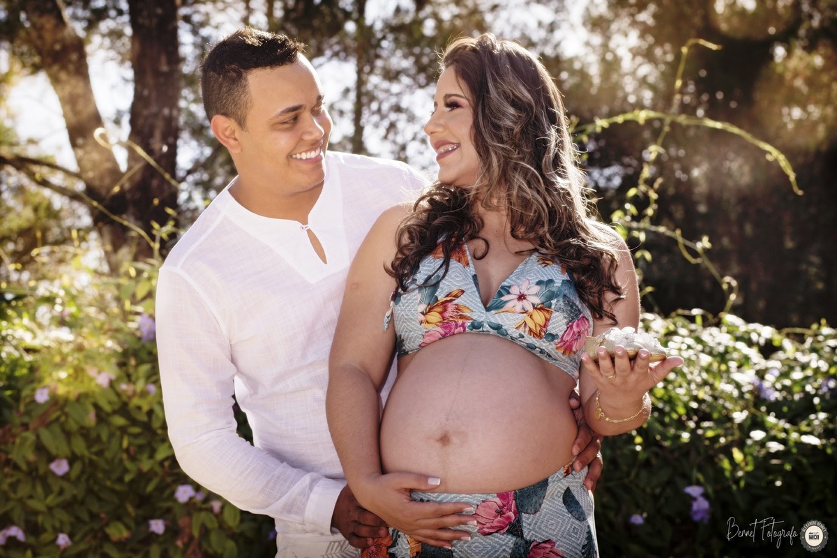 Casal se olha com sapatinho do bebê na mão 