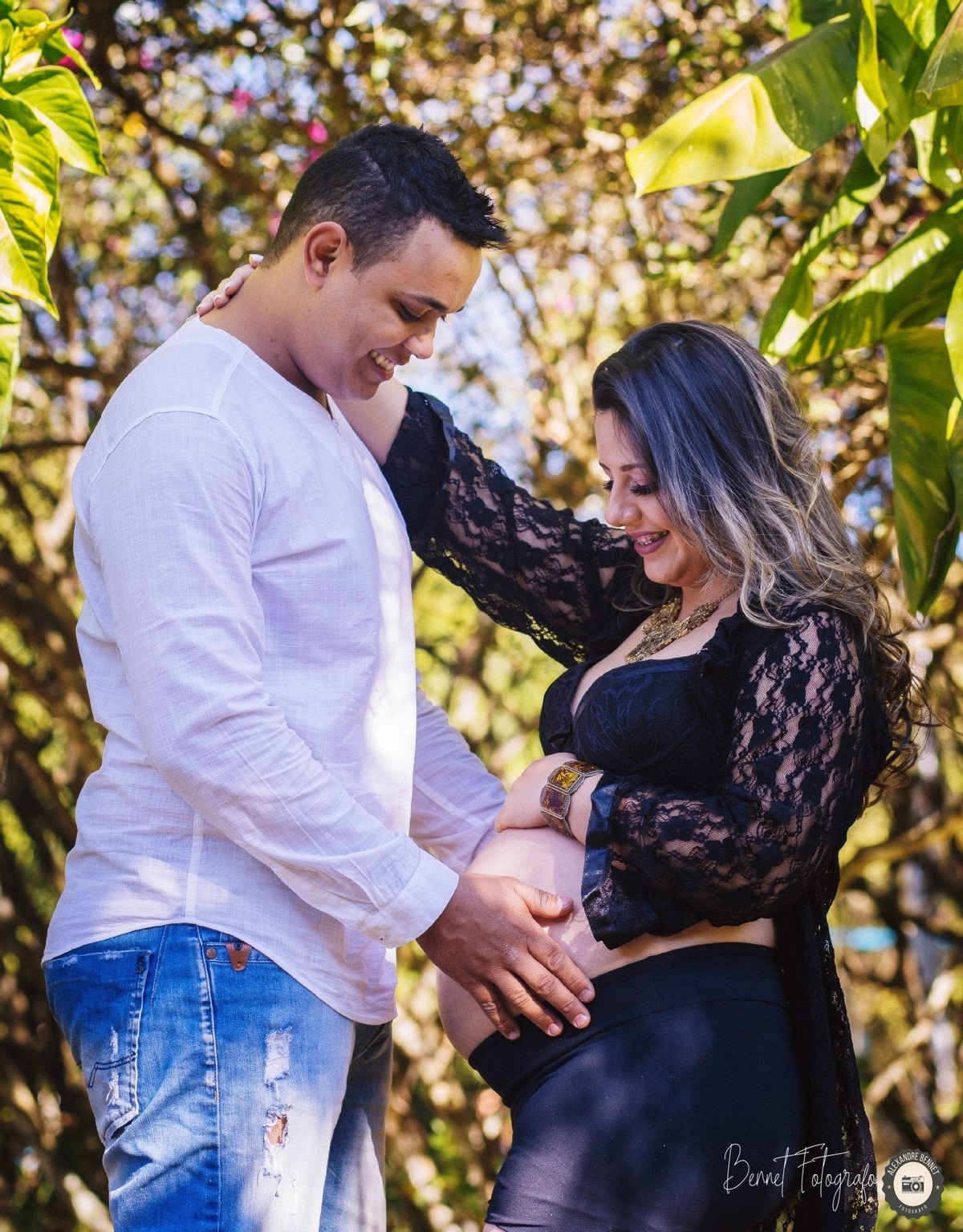 Pais olham para a barriga e sorriem 