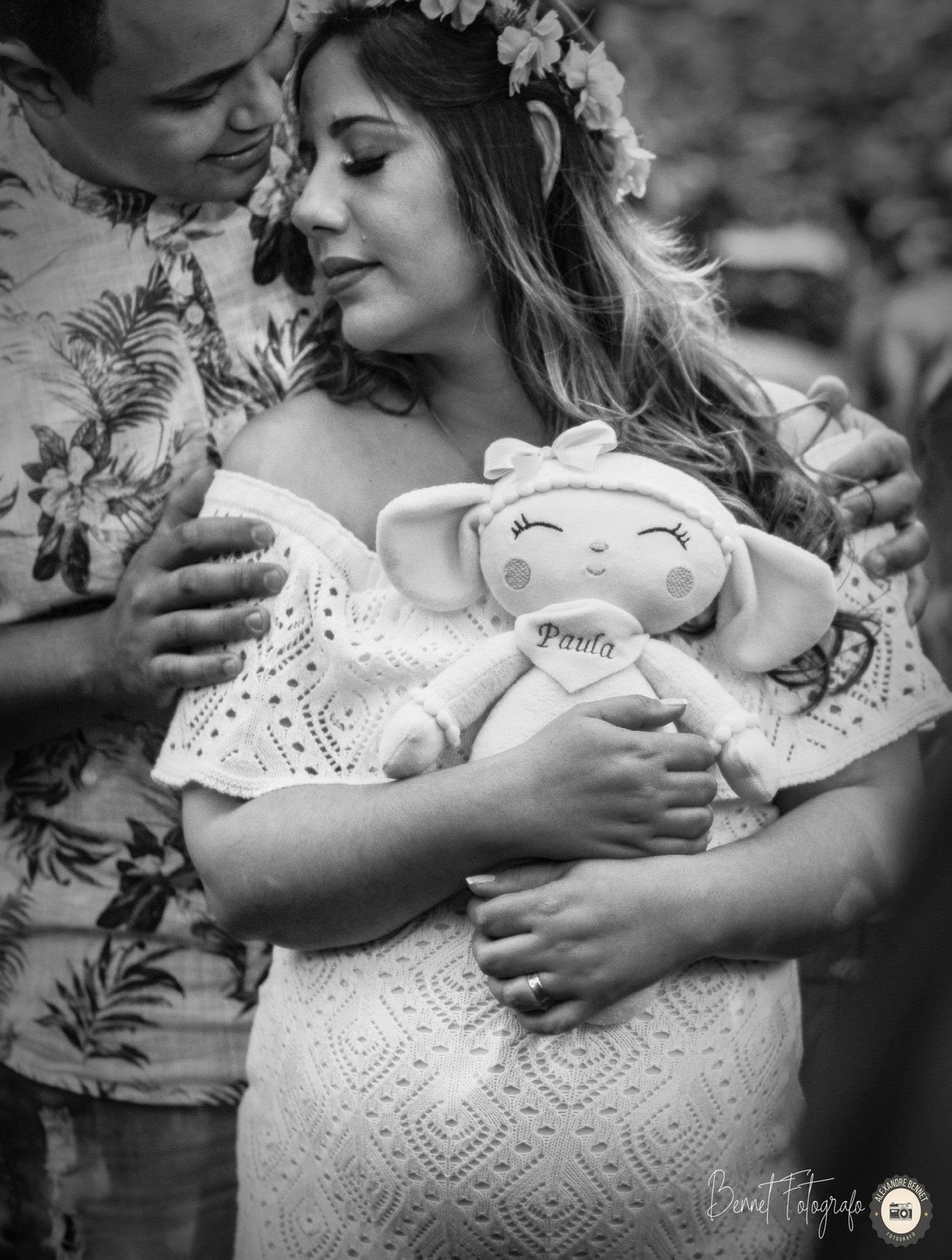 Mãe segura boneca de sua filha enquanto pai a beija 