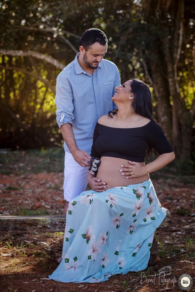 Pai coloca sapatinho do bebê na barriga da futura mamãe 