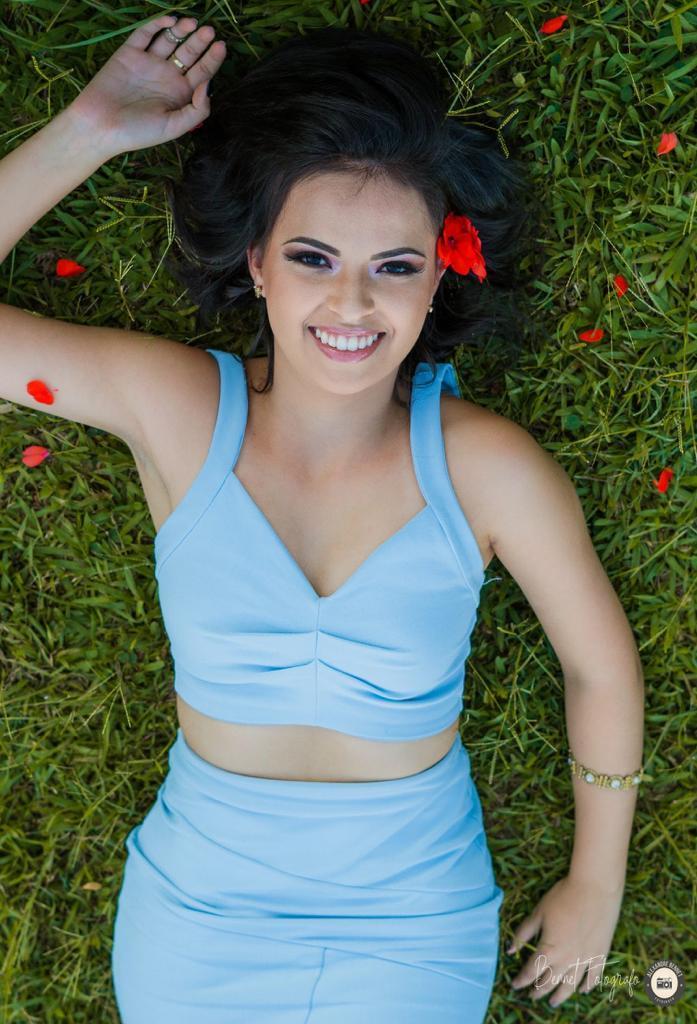 Debutante deita no chão com flores nos cabelos