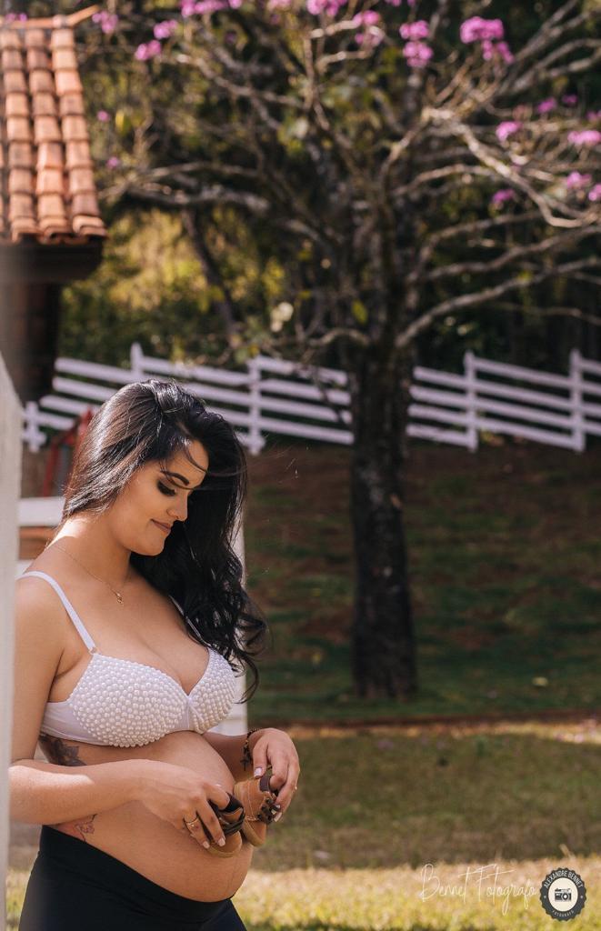 Mãe posiciona sapatinhos do bebê em sua barriga