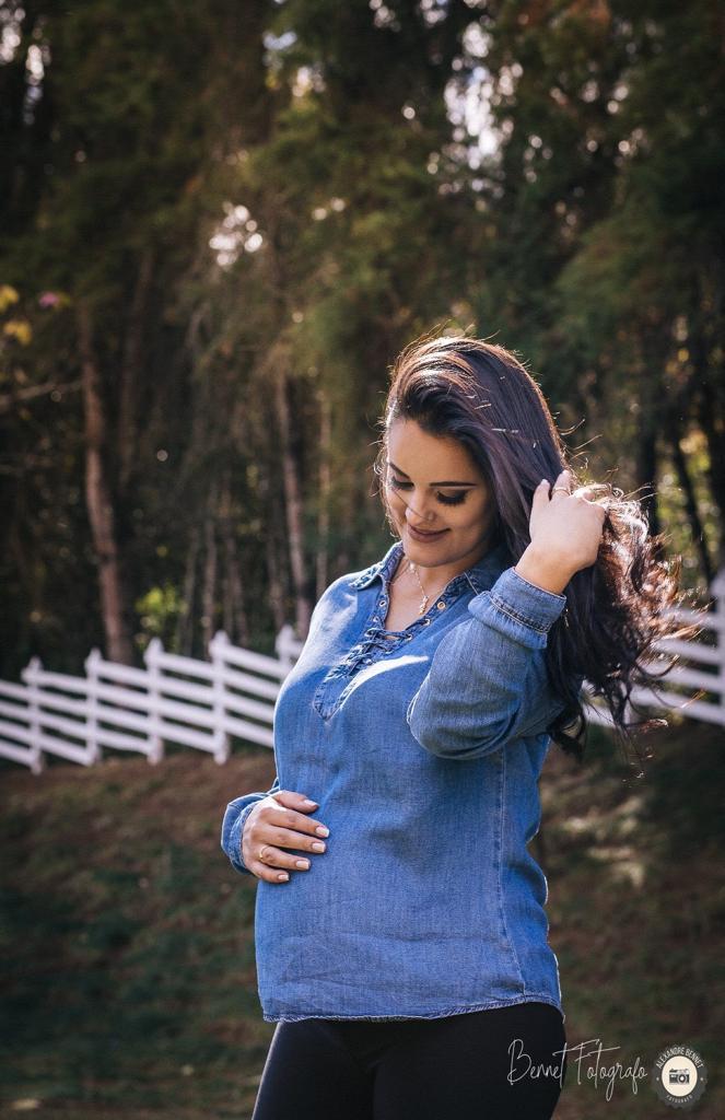 Mãe mexe no cabelo enquanto ollha pra sua barriga 
