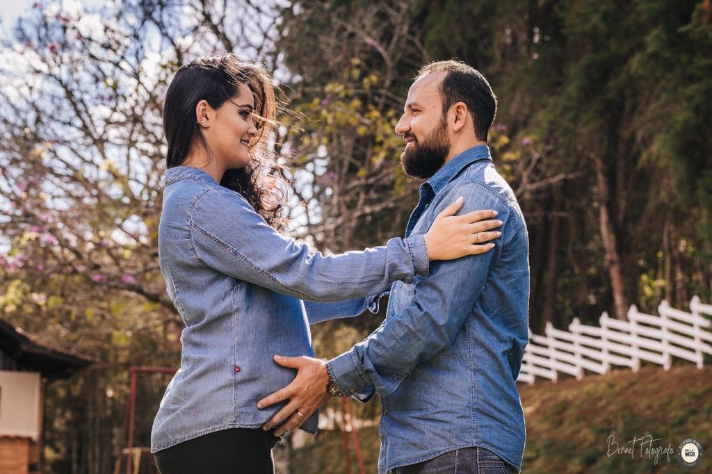 Pais se olham enquanto pai coloca a mão na barriga 