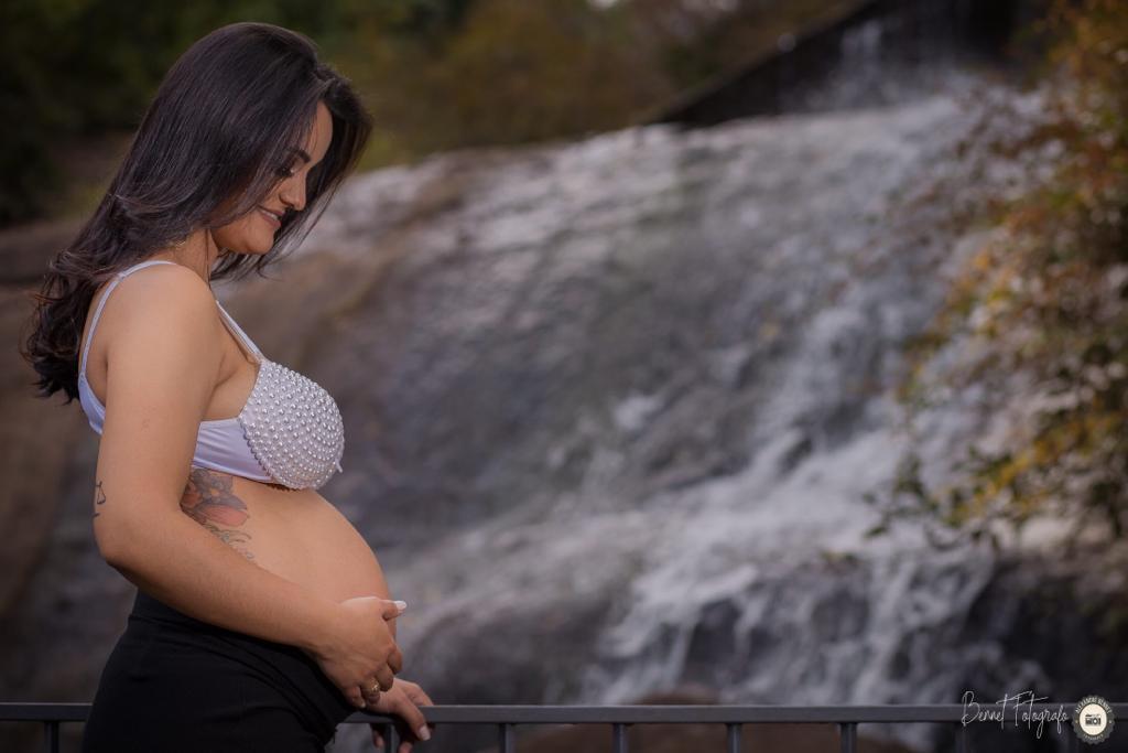 Mãe fotografada em frente a cachoeira 