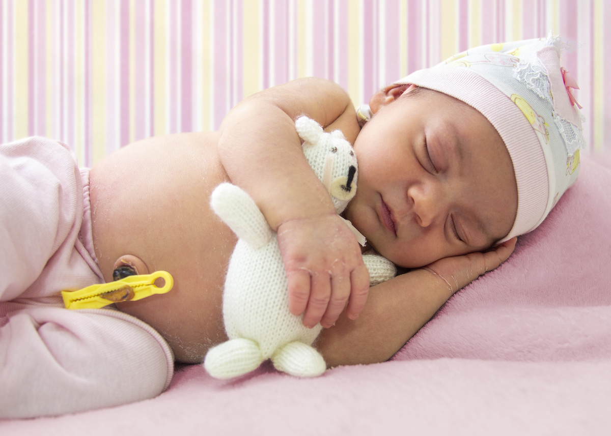 newborn-7-dias-deitada-com-ursinho branco-e-touquinha-combinando-com-o-pijaminha-deitada-de-ladinho-fotografo-marcos-toledo-acompanhamento-infantil-alvorada-omeufotografo.com.br