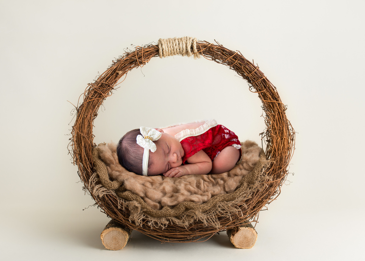 newborn-7-dias-deitada-de-ladinho-com-a-mao-no-lado-do-rostinho-na-cestinha-de-cipo-fotografo-marcos-toledo-acompanhamento-infantil-alvorada-omeufotografo.com.br