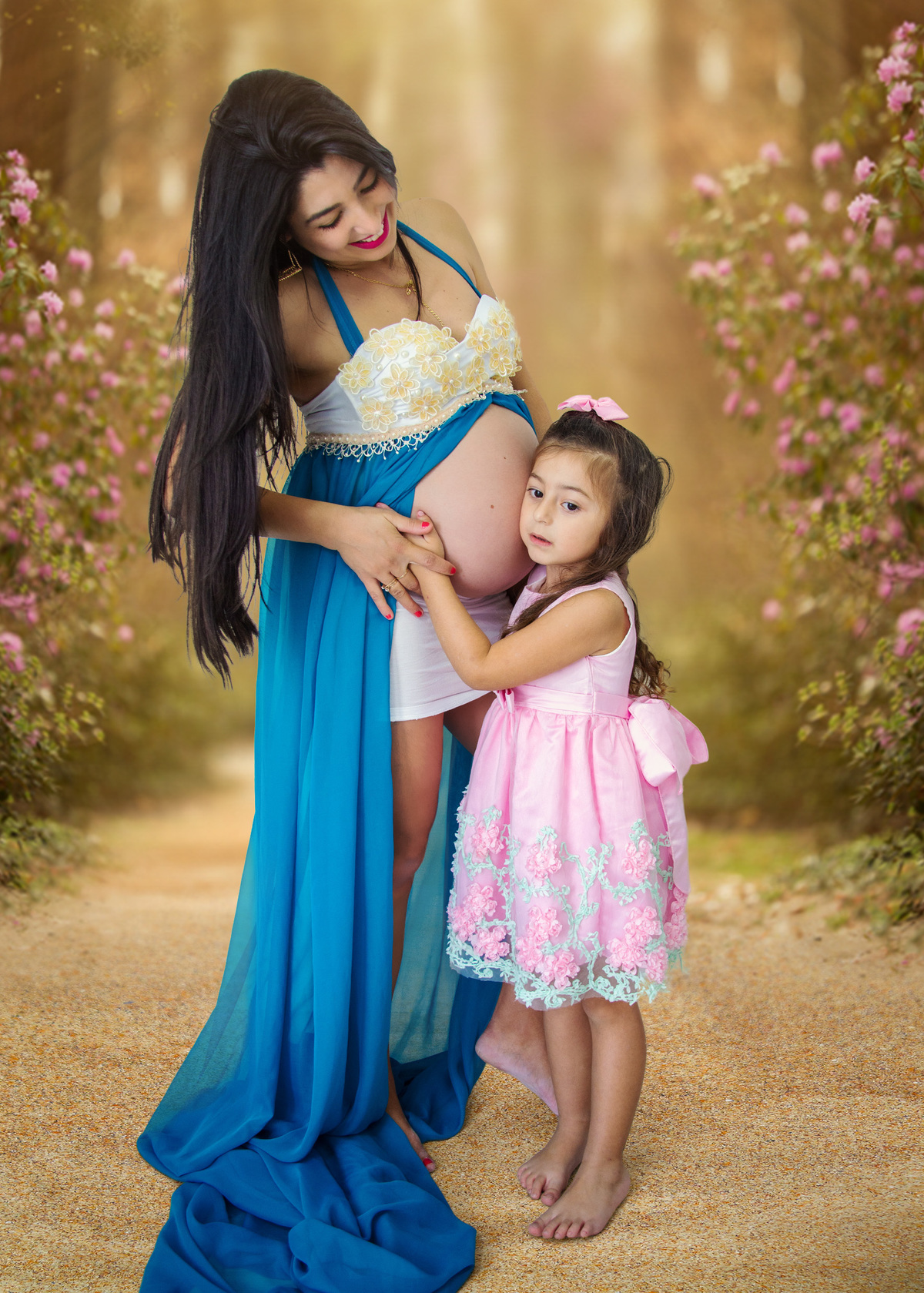 fotografo marcos toledo registra mamae gestante e sua filhinha mais velha com vestido rosa tentando escutar o bebê