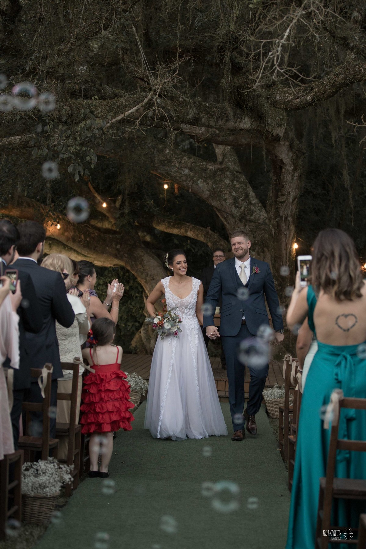 casamento ao ar livre sitio da figueira com luzinhas de dia fotografo de casamento porto alegre RS organizacao welove decoracao tais puntel vestido da noiva atelie sandra ferraz sal da terra fotografia saida com bolhas de sabao