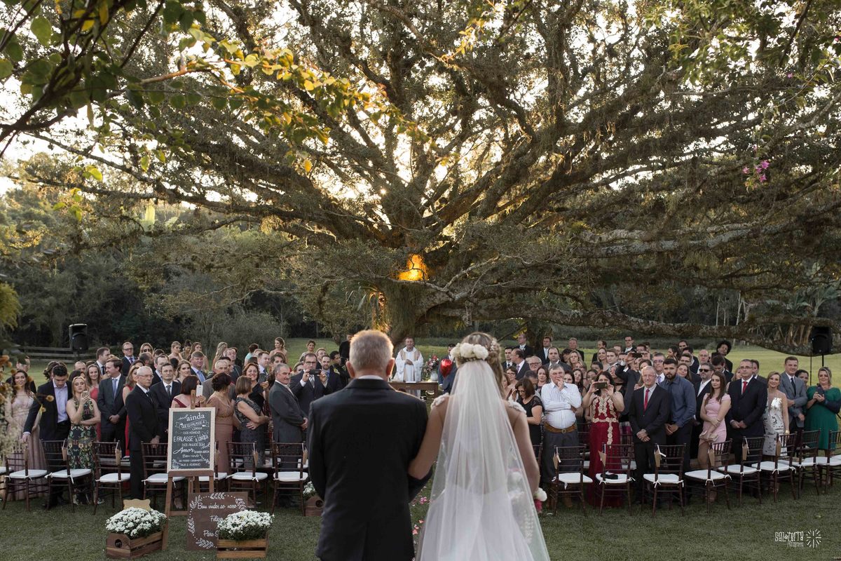 casamento ao ar livre em baixo da figueira alto da capela porto alegre entrada da noiva vestido marco tarrago traje franzn alfaiataria decoracao cor de perola fotografo de casamento no brasil