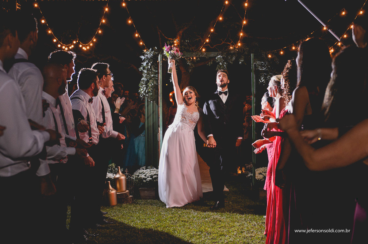 Noivos saindo do altar e noiva levantou o bouquet.