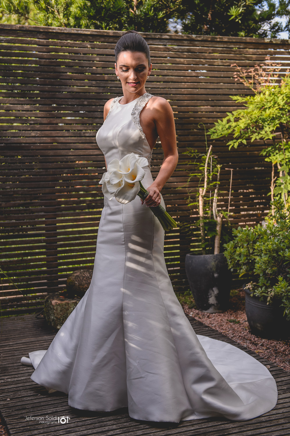 Detalhe da noiva segurando o bouquê com uma mão.