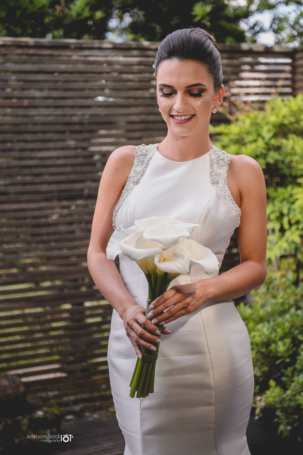 Detalhe da noiva segurando o bouquê com as duas mãos. 