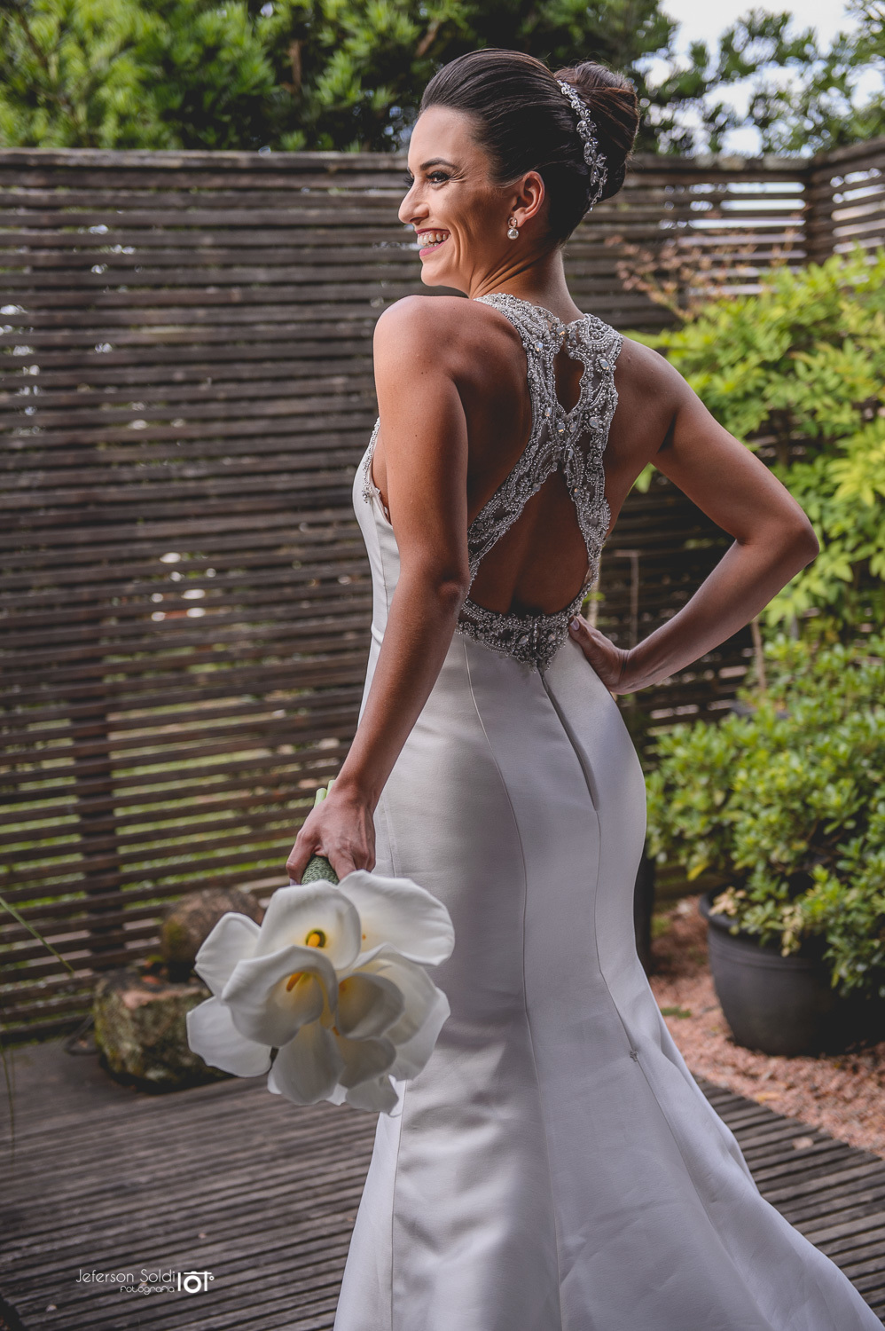 Detalhe evidenciando as costas do vestido da noiva todo bordado em pedrarias.