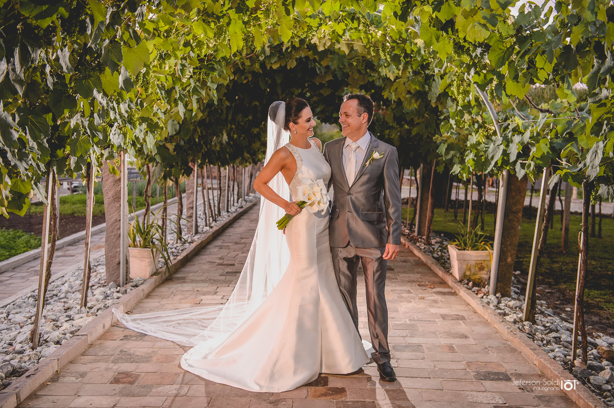 Casal deixando o altar por entre o parreiral.
