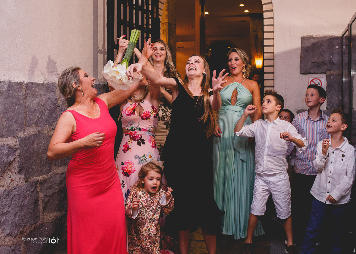 Uma das amigas da noiva pegando o bouquê.