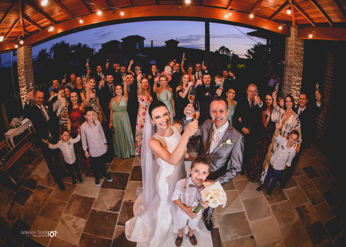 Uma foto geral com os noivos brindando com seus convidados.