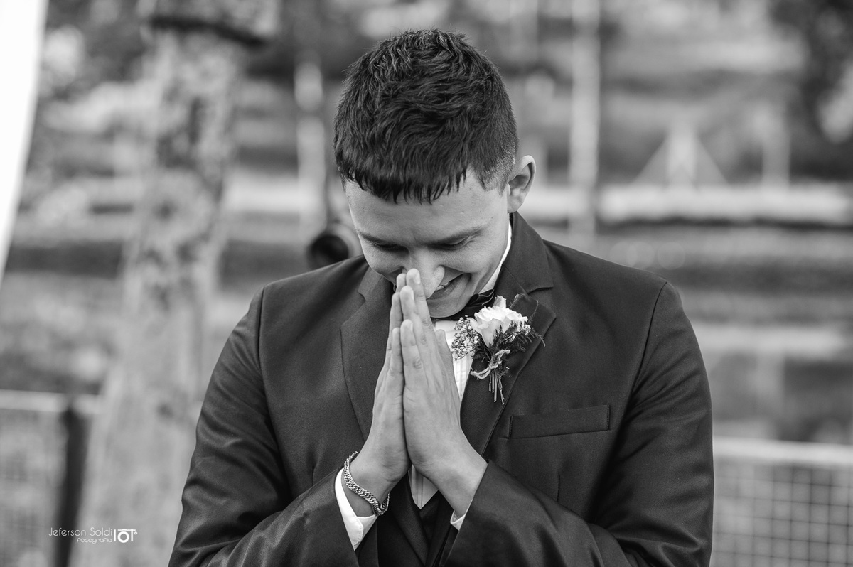 Noivo com as duas mãos juntas, em sinal de gratidão.
