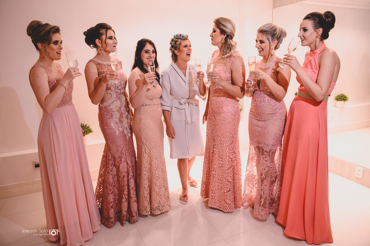 Noiva e suas madrinhas brindando na estética.