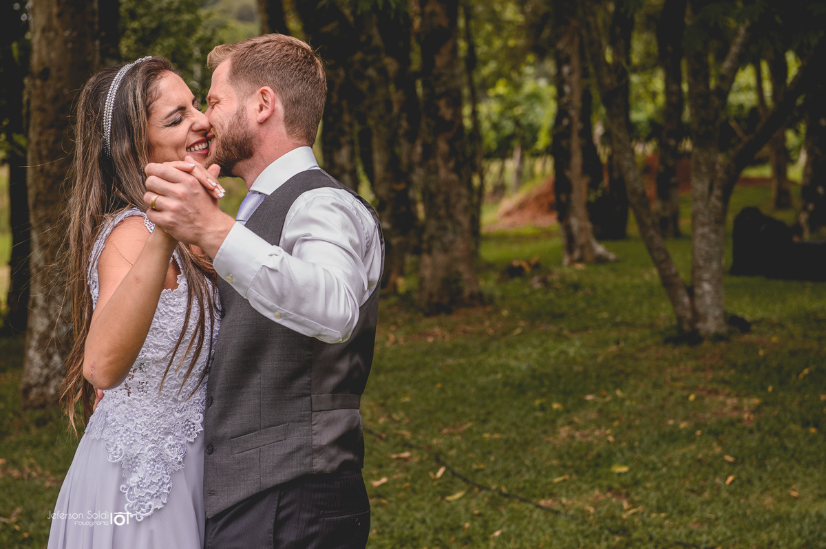 Casal dançando sob as arvores.