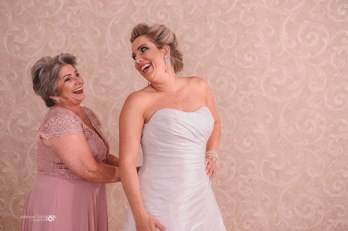 Mãe da Nova ajudando a fechar o vestido.