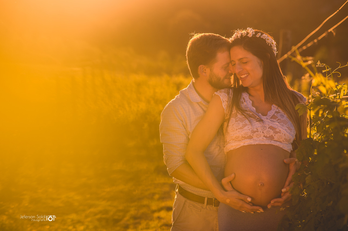 Casal gestante sorrindo abraçadinhos