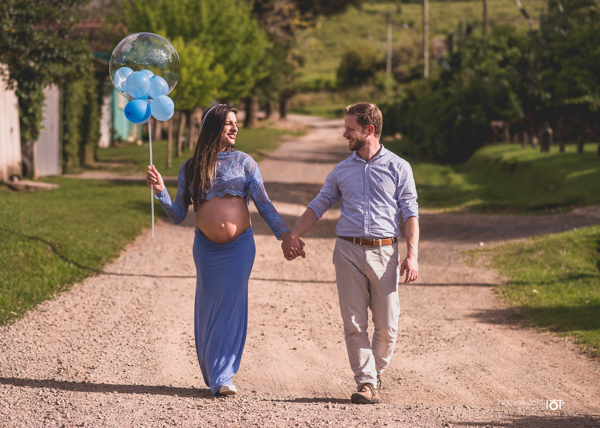 casal gestante caminhando de mãos dadas pela estrada linda em uma tarde ensolarada

