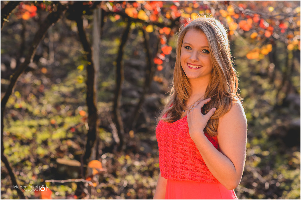 Elisa com seu vestido laranja olhando pra câmera